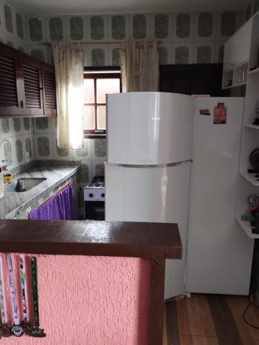 a kitchen with a white refrigerator and a sink at Residência Itaúna in Saquarema