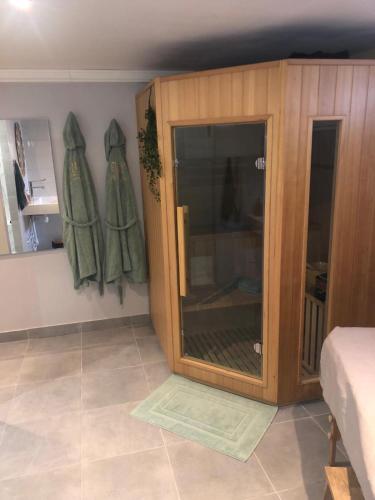- une chambre avec une armoire en bois et une porte en verre dans l'établissement Chambre detente en Harmonie, à Saint-Ouen-lʼAumône