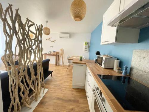 Il comprend une cuisine avec des murs bleus et un comptoir en bois. dans l'établissement Le Grand Large - Appartement Centre Concarneau, à Concarneau