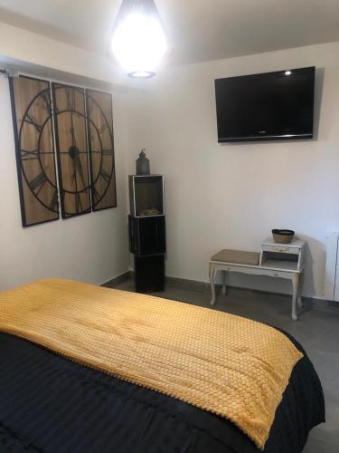 une chambre avec un lit et une télévision à écran plat dans l'établissement Chambre detente en Harmonie, à Saint-Ouen-lʼAumône