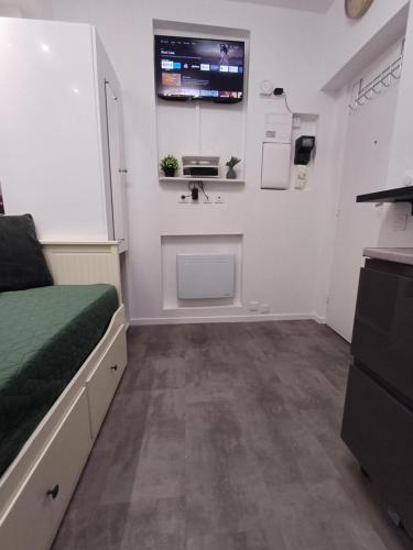 a bedroom with a bed and a sink and a tv at Bright small studio Paris Saint Ouen in Saint-Ouen
