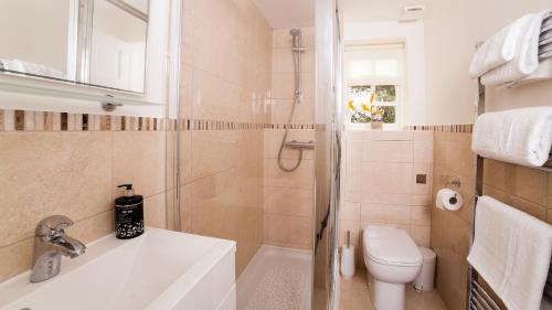 Un baño con bañera, inodoro y lavabo. en Fort Victoria Cottages - Spinnakers, en Yarmouth