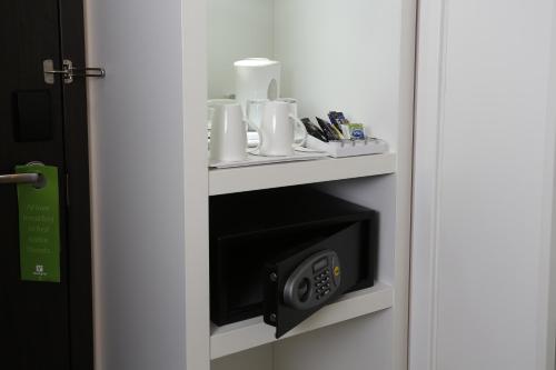 a room with a wall mounted microwave in a room at Holiday Inn Southend by IHG in Southend-on-Sea
