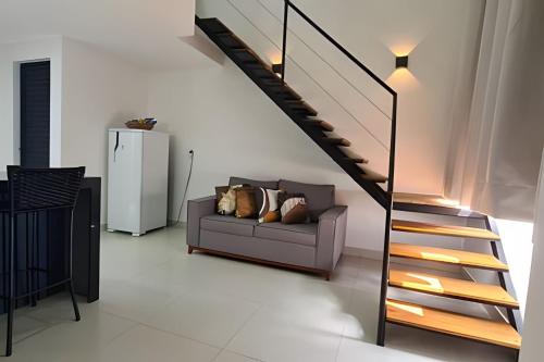a living room with a couch and a staircase at LINDOS LOFTS PRÓXIMO AO LITORAL SUL in Parnamirim