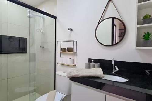 a bathroom with a sink and a mirror at LINDOS LOFTS PRÓXIMO AO LITORAL SUL in Parnamirim