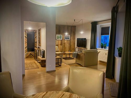 a living room with a couch and a table and chairs at Mozaika Art Apartment PL LT EN in Suwałki