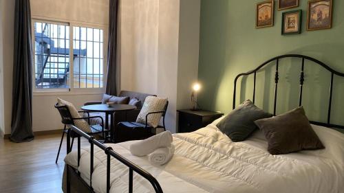1 dormitorio con 1 cama, mesa y sillas en Casa Cervantes Malaga, en Málaga