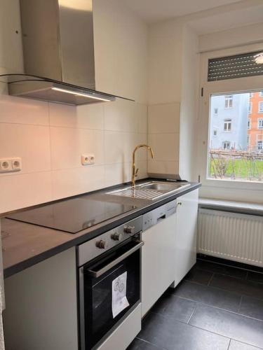 a kitchen with a sink and a stove top oven at DE Apartment in Neu Ulm