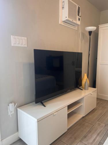 a flat screen tv sitting on a white entertainment center at Private modern guesthouse, near La Cantera/Medical Center in San Antonio