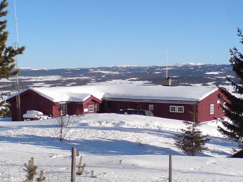 un granero rojo con nieve encima en Kontakten by Norgesbooking - large cabin for families and groups, en Gol