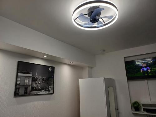 a kitchen with a refrigerator and a ceiling light at Bright small studio Paris Saint Ouen in Saint-Ouen