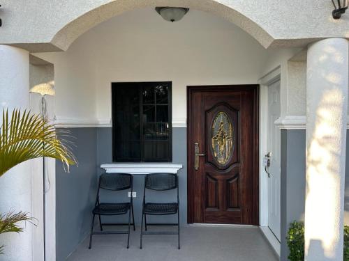 two chairs sitting at a counter in front of a door at Meadows Place in Montego Bay