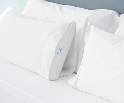 a pile of white pillows on a bed at Embassy Suites by Hilton at Hot Springs Convention Center in Hot Springs