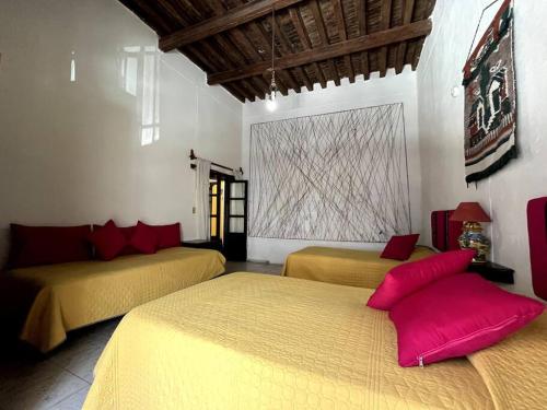 two beds in a room with red pillows on them at Casa colonial céntrica Guanajuato in Guanajuato