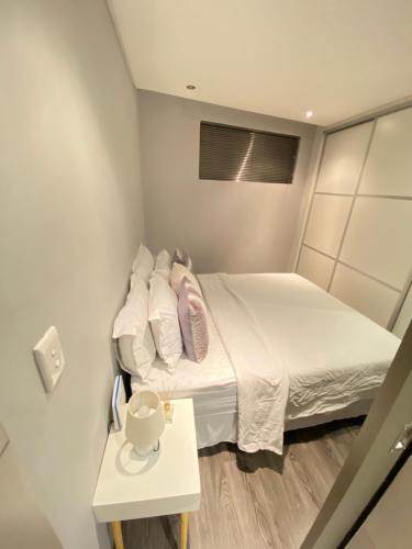 Kleines Zimmer mit einem Bett und einem Tisch in der Unterkunft Windhoek Oliver perfect stays in Windhoek