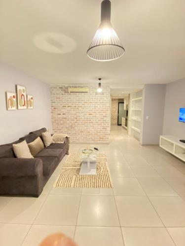 ein Wohnzimmer mit Sofa und Ziegelwand in der Unterkunft Windhoek Oliver perfect stays in Windhoek