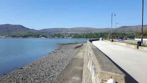 a road next to a body of water at The Lough & Quay Accommodation in Warrenpoint