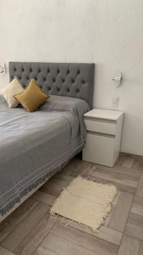 a bedroom with a bed with a tufted headboard and a rug at 12 Olivos Cabañas in San Rafael