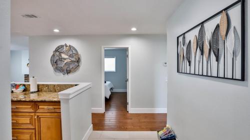 a kitchen with white walls and a counter with feathers on the wall at H&H Modern Lux 4BD 1 King Suite 3 Queen SoCal Disney in Westminster