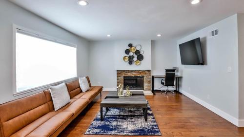a living room with a couch and a fireplace at H&H Modern Lux 4BD 1 King Suite 3 Queen SoCal Disney in Westminster