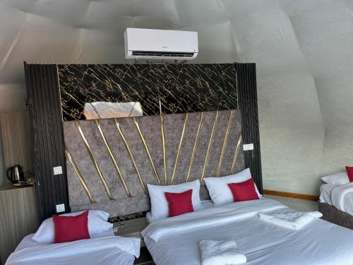 Habitación de hotel con 2 camas con almohadas rojas en Bacific camp en Wadi Rum
