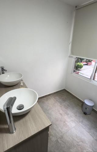 卡利的住宿－Unidad cerca a cosmocentro，白色的浴室设有水槽和窗户。