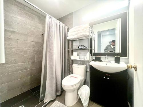 a bathroom with a toilet and a sink and a mirror at Westview Vacation Rental - Two BR House in North Vancouver