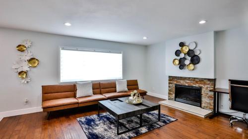 a living room with a couch and a fireplace at H&H Modern Lux 4BD 1 King Suite 3 Queen SoCal Disney in Westminster