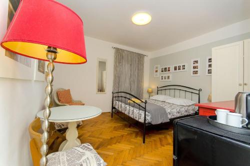 a room with a bed and a table and a lamp at Apartment Martini in Split