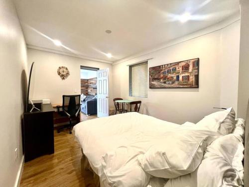 a bedroom with a white bed and a desk at Westview Vacation Rental - Two BR House in North Vancouver