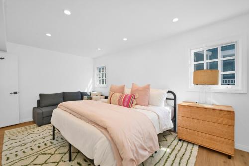 a white bedroom with a bed and a couch at Chic Modern Designed Home with Private Studio in Newport Beach