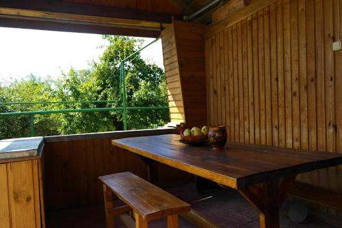 a wooden table with a bowl of fruit on a porch at Guest House Varvarinskiy in Suzdal