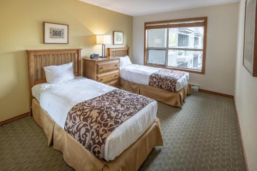 um quarto de hotel com duas camas e uma janela em The Aspens by TS em Whistler