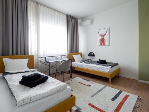 een kamer met 2 bedden, een tafel en een raam bij Central Apartment Parking Two Bedrooms Sky Terrace in Sofia