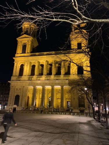un grand bâtiment avec une tour la nuit dans l'établissement Mignonne, à Paris