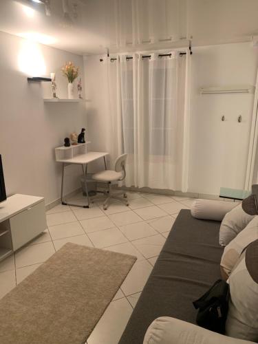 - un salon blanc avec une table et un bureau dans l'établissement Mignonne, à Paris