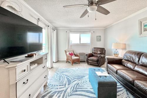uma sala de estar com um sofá e uma televisão de ecrã plano em Regency Towers em Panama City Beach