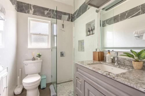La salle de bains est pourvue de toilettes, d'un lavabo et d'une douche. dans l'établissement Manhattan Beach Family Suite Stylish 2 BR 1BA Parking, à Manhattan Beach