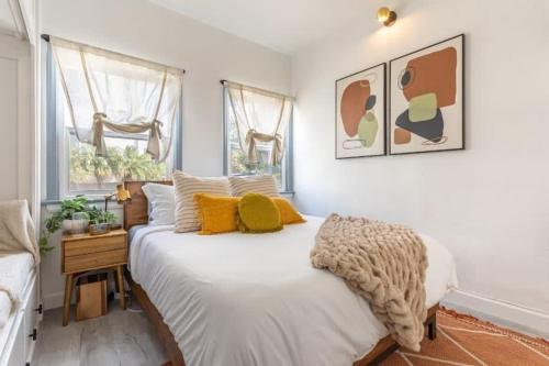 a bedroom with a large white bed with yellow pillows at Manhattan Beach Family Suite Stylish 2 BR 1BA Parking in Manhattan Beach