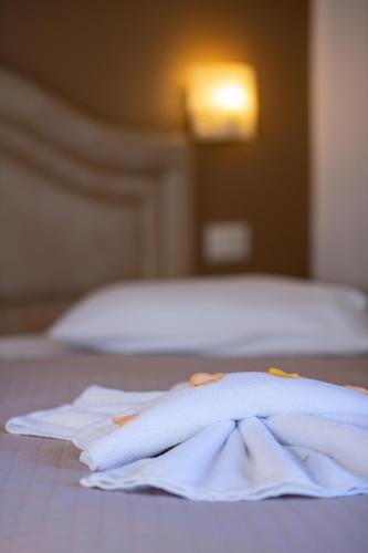 a pile of towels sitting on top of a bed at Kronos Hotel in Heraklio Town