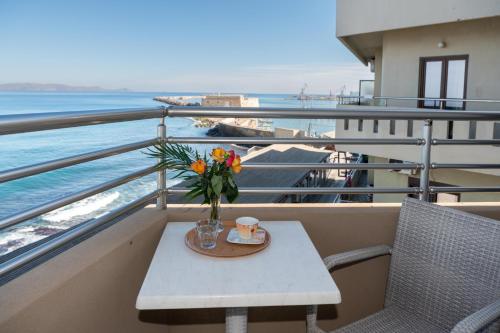 a table with a vase of flowers on a balcony at Kronos Hotel in Heraklio Town