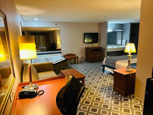a hotel room with a bed and a bath tub at Royal Inn Suites in Huntington