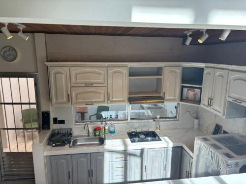 una cocina con armarios blancos y fregadero en Moderna casa en el corazon de Leticia, en Leticia