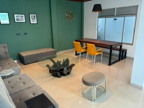 ein Wohnzimmer mit einem Sofa, einem Tisch und Stühlen in der Unterkunft Moderna casa en el corazon de Leticia in Leticia