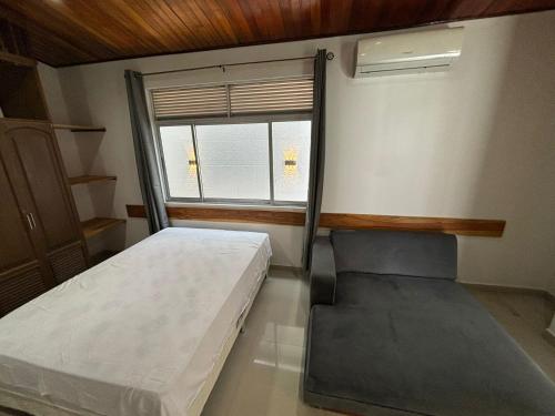 ein kleines Schlafzimmer mit einem Bett und einem Fenster in der Unterkunft Moderna casa en el corazon de Leticia in Leticia