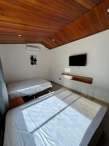 a bedroom with two beds and a flat screen tv at Moderna casa en el corazon de Leticia in Leticia
