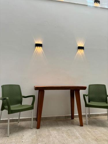 einen Tisch mit zwei Stühlen und zwei Lampen an der Wand in der Unterkunft Moderna casa en el corazon de Leticia in Leticia