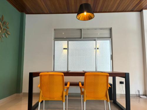 einen Esstisch mit gelben Stühlen und ein Fenster in der Unterkunft Moderna casa en el corazon de Leticia in Leticia