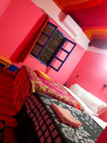 a bedroom with pink walls and a bed with a comforter at Luna del fuego in Ifri