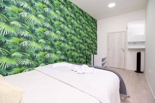 1 dormitorio con cama blanca y pared verde en Downtown Cozy Apartment, en Sarajevo
